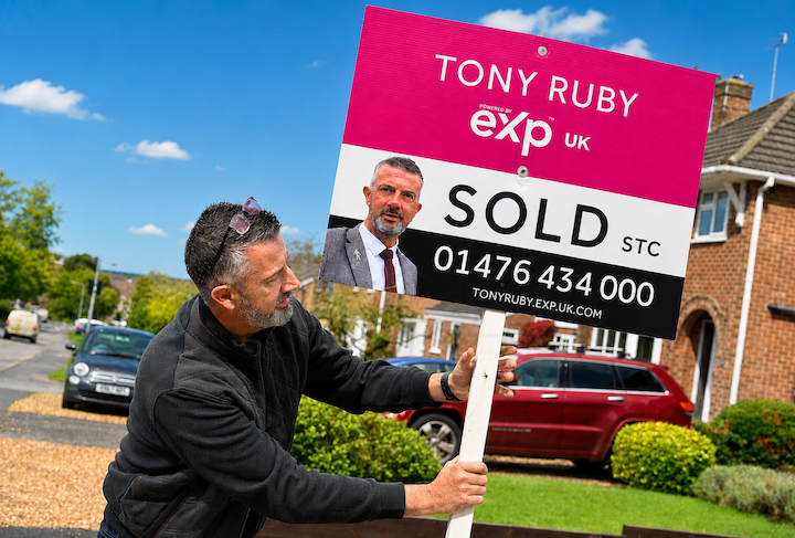 Tony Ruby putting up a sold board outside a house in Grantham